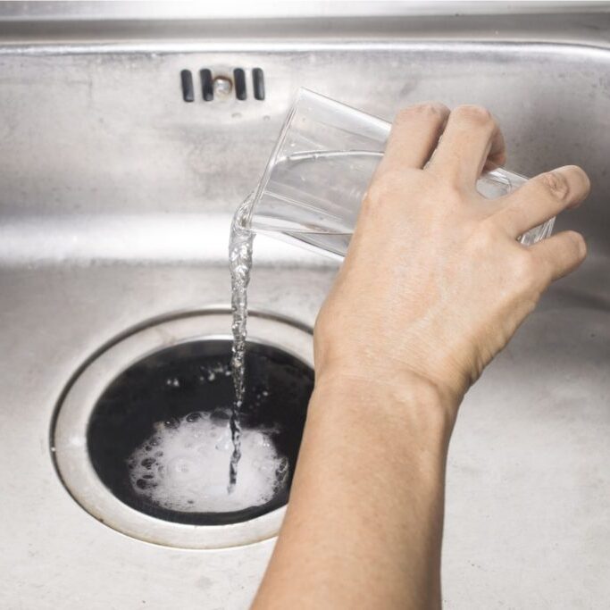 pouring water down the drain