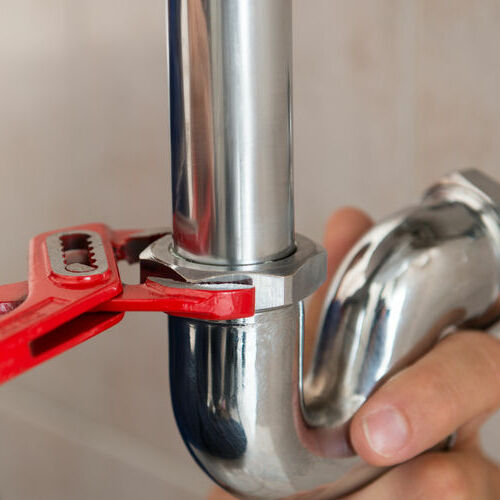 An Emergency Plumber Repairs a Pipe.