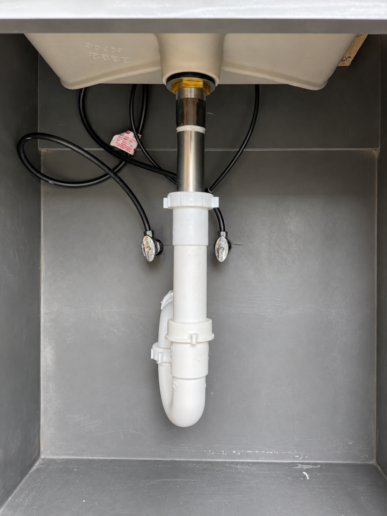 Under-sink drain assembly in a residential cabinet