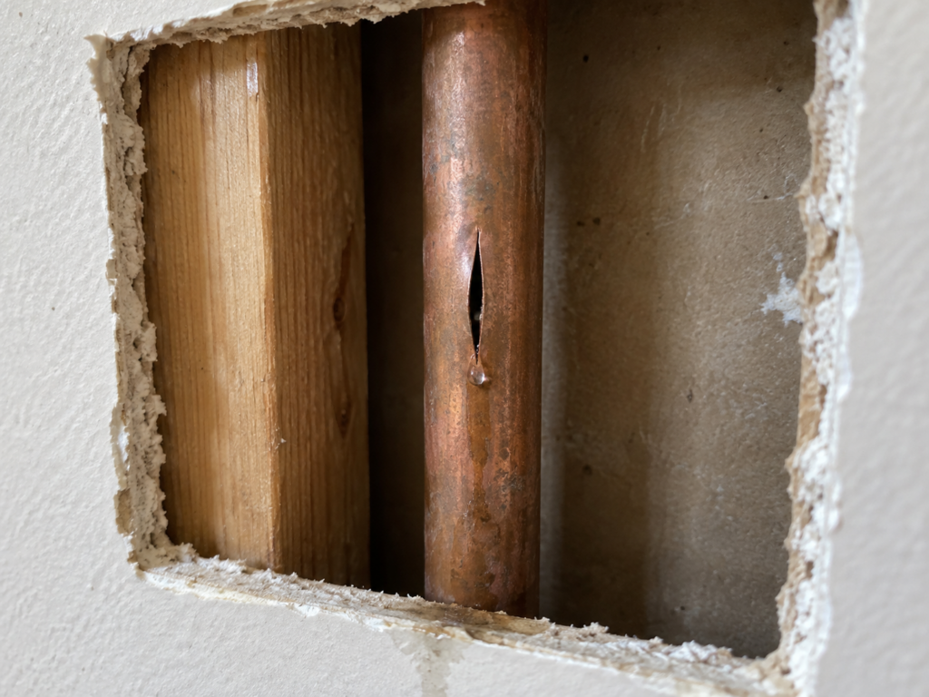 Damaged water pipe exposed for inspection before repair